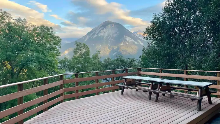Terrasse du chalet offrant un espace calme pour déguster un goûter tout en admirant les montagnes.